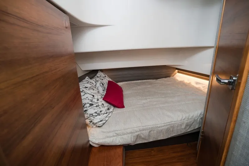 Slide: The Image of Cozy cabin interior of 2020 Tiara Sport 34 LS with wooden accents and bedding. - 32