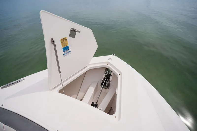 Slide: The Image of 2020 Tiara Sport 34 LS boat anchor compartment open on calm water. - 29