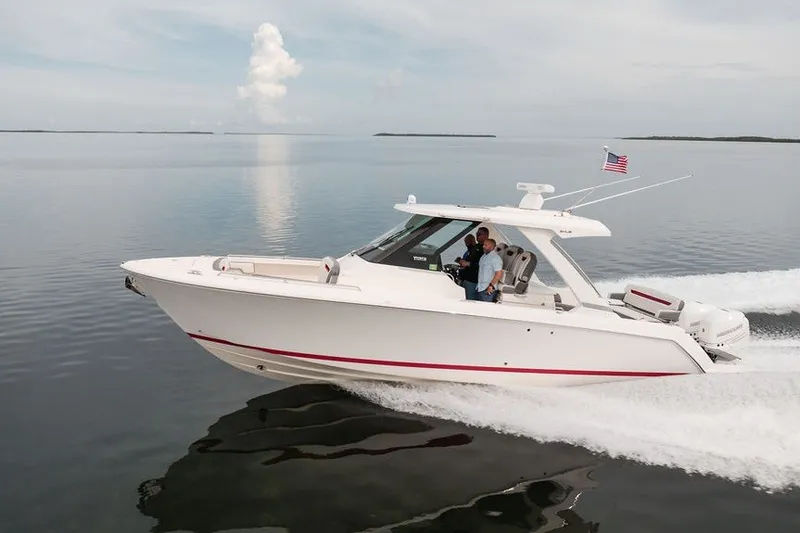 Slide: The Image of 2020 Tiara Sport 34 LS boat cruising on calm water with American flag. - 5