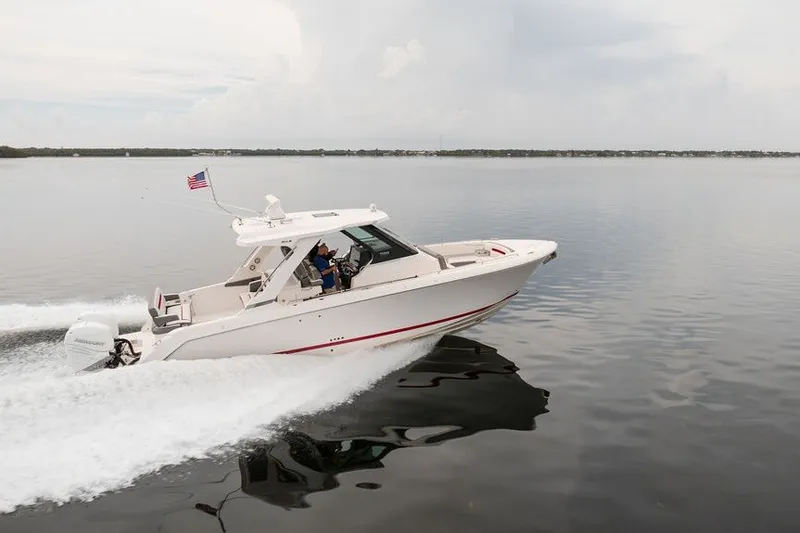 Slide: The Image of 2020 Tiara Sport 34 LS boat cruising on calm water with American flag. - 3