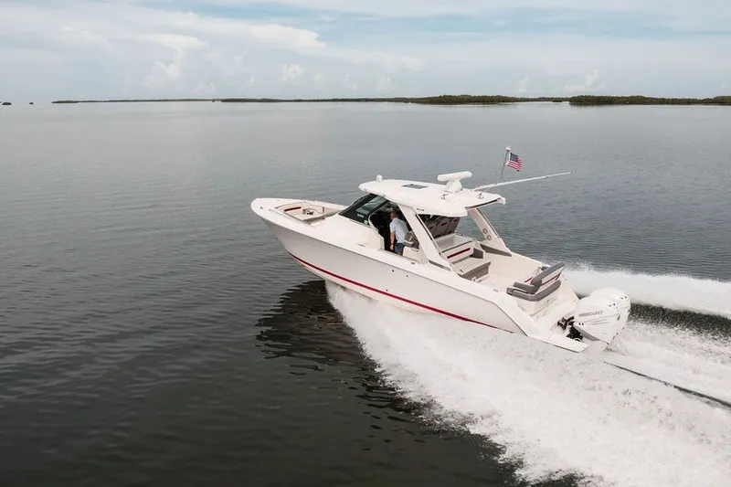 Slide: The Image of 2020 Tiara Sport 34 LS boat cruising on calm waters under a clear sky. - 11