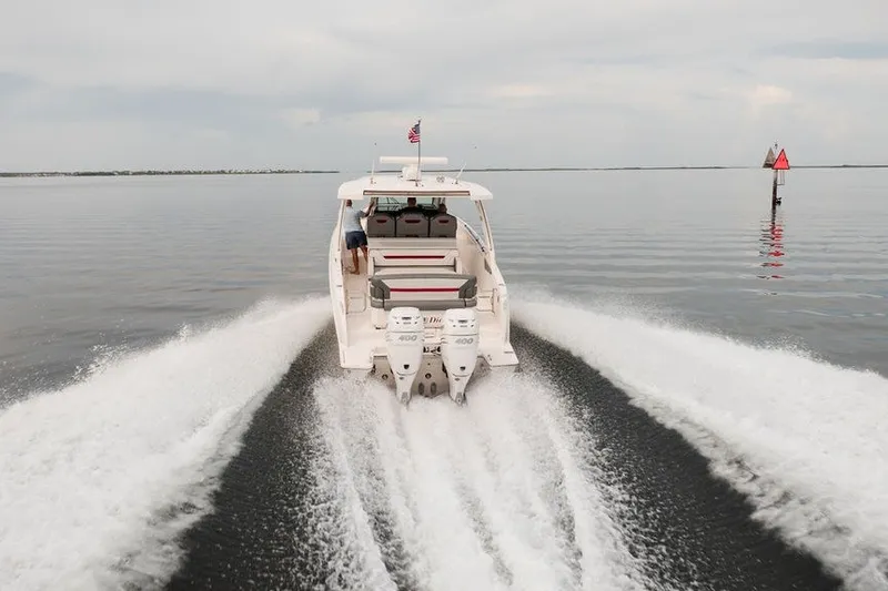 Slide: The Image of 2020 Tiara Sport 34 LS boat cruising on calm water, rear view. - 4