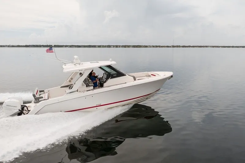 Slide: The Image of 2020 Tiara Sport 34 LS boat cruising on calm water with American flag. - 6