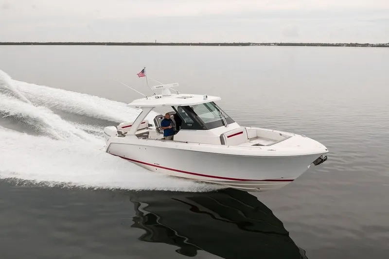 Slide: The Image of 2020 Tiara Sport 34 LS boat cruising on calm water with American flag. - 7