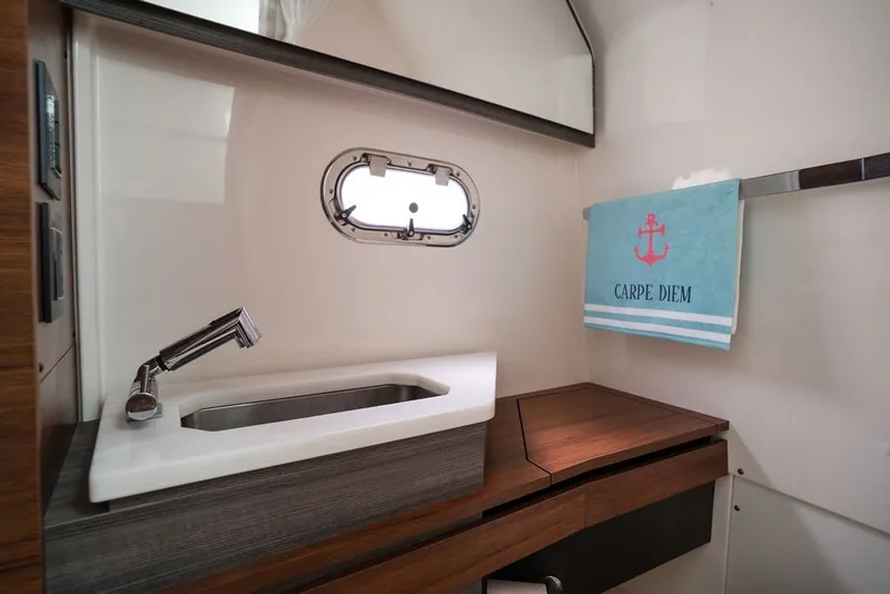 Slide: The Image of 2020 Tiara Sport 34 LS yacht bathroom with modern sink and "Carpe Diem" towel. - 36
