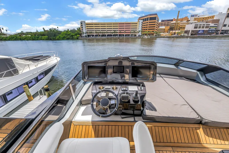 Slide: The Image of Flybridge of 2022 OKEAN 50 yacht with modern controls, docked by waterfront buildings. - 69
