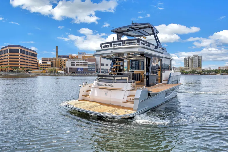 Slide: The Image of 2022 OKEAN 50 Flybridge yacht cruising in urban waterfront setting under blue skies. - 12