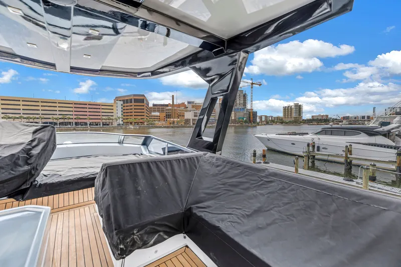 Slide: The Image of 2022 OKEAN 50 Flybridge yacht docked, featuring sleek design and waterfront cityscape. - 99