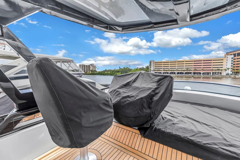 Slide: The Image of 2022 OKEAN 50 Flybridge yacht with covered seating, docked near waterfront buildings. - 89
