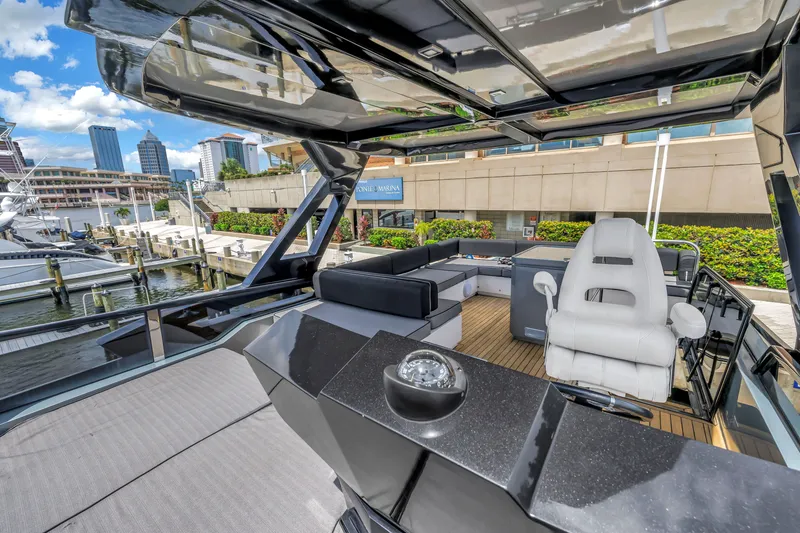 Slide: The Image of Flybridge of 2022 OKEAN 50 yacht, featuring modern seating and city marina backdrop. - 74