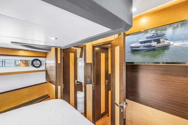 Slide: The Image of Luxurious interior of 2022 OKEAN 50 Flybridge yacht with modern wood finishes and TV display. - 42