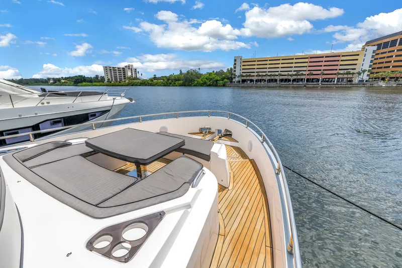 Slide: The Image of Luxurious 2022 OKEAN 50 Flybridge yacht on serene waterfront with cityscape backdrop. - 50