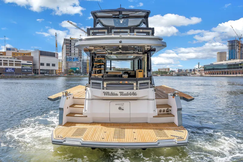 Slide: The Image of 2022 OKEAN 50 Flybridge yacht on water, cityscape background. - 13