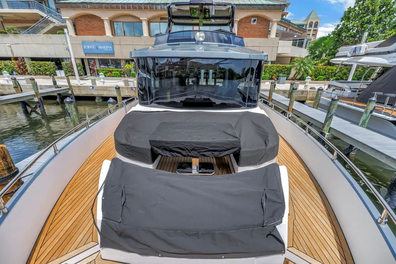 Slide: The Image of 2022 OKEAN 50 Flybridge yacht docked at marina, featuring sleek design and covered seating. - 96