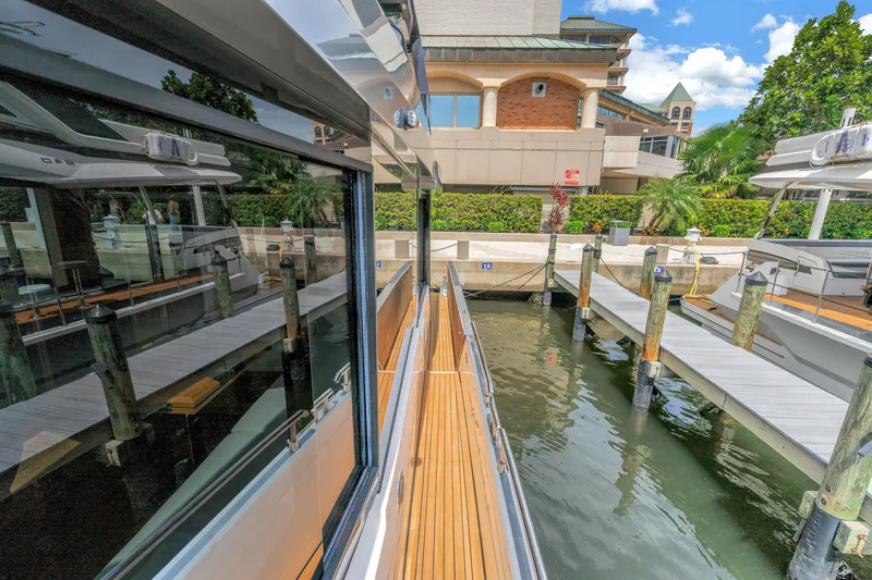 Slide: The Image of 2022 OKEAN 50 Flybridge yacht docked at marina with modern architecture. - 58