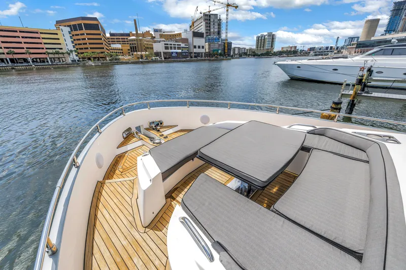 Slide: The Image of Luxurious 2022 OKEAN 50 Flybridge yacht with spacious deck seating, docked in urban marina. - 56