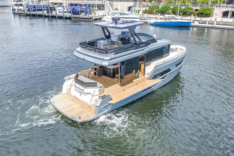 Slide: The Image of 2022 OKEAN 50 Flybridge yacht cruising in a marina, showcasing sleek design and spacious deck. - 11