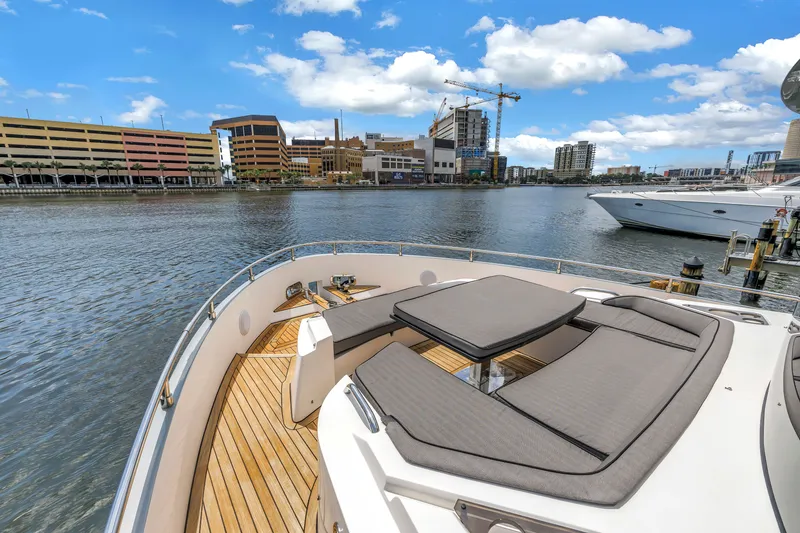 Slide: The Image of Luxurious 2022 OKEAN 50 Flybridge yacht with elegant deck seating, docked in urban marina. - 57