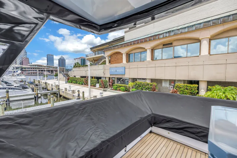 Slide: The Image of Flybridge view from 2022 OKEAN 50 yacht at a marina with cityscape background. - 100