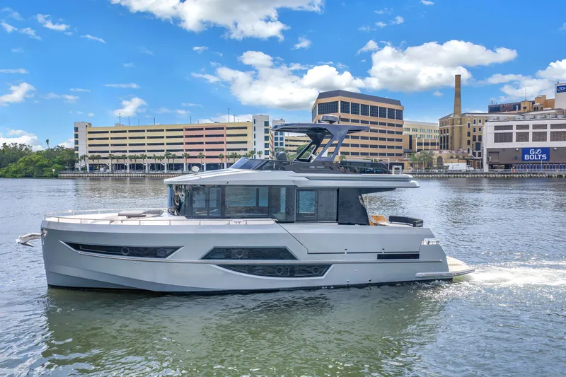 Slide: The Image of 2022 OKEAN 50 Flybridge yacht cruising on a sunny day near urban waterfront. - 2
