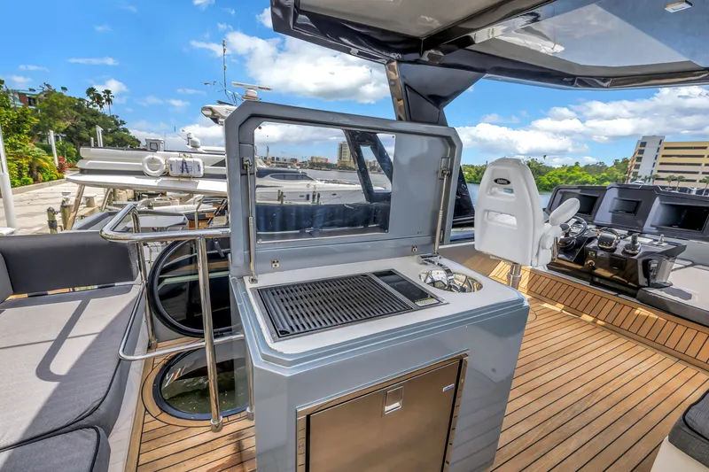 Slide: The Image of Flybridge of 2022 OKEAN 50 yacht with grill and seating, under clear blue sky. - 75
