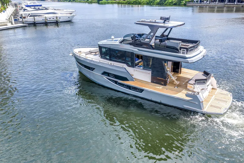 Slide: The Image of 2022 OKEAN 50 Flybridge yacht cruising on a serene river. - 5