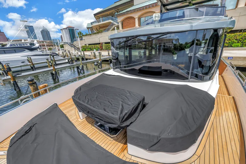 Slide: The Image of 2022 OKEAN 50 Flybridge yacht docked, featuring sleek design and covered seating area. - 92