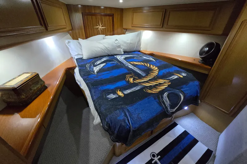 Slide: The Image of Luxurious cabin interior of 2006 Jersey Cape 44 Convertible yacht with nautical-themed bedding. - 16