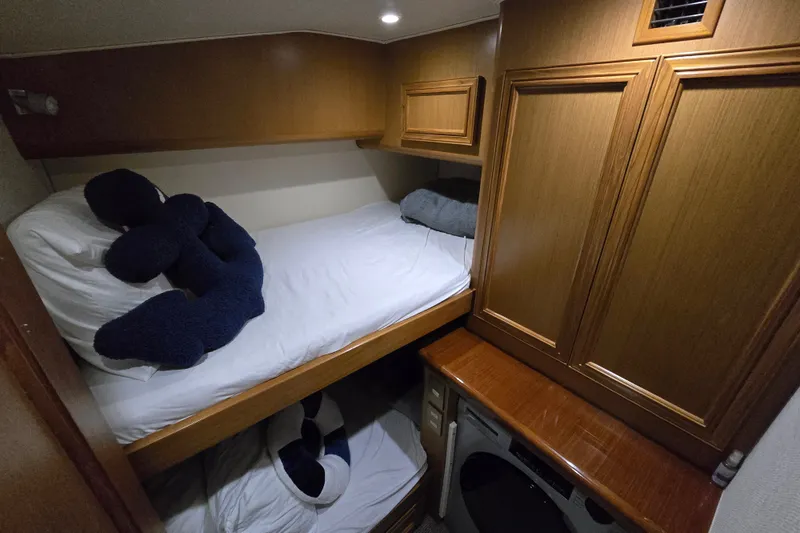 Slide: The Image of Cozy cabin interior of 2006 Jersey Cape 44 Convertible with bunk beds and wooden cabinetry. - 21