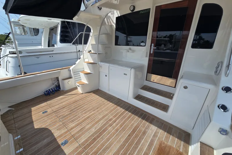 Slide: The Image of 2006 Jersey Cape 44 Convertible yacht deck with teak flooring and sleek white cabinetry. - 38
