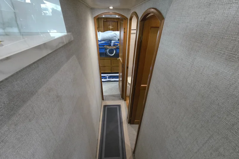 Slide: The Image of Narrow hallway inside 2006 Jersey Cape 44 Convertible yacht with wooden doors and carpeted floor. - 24