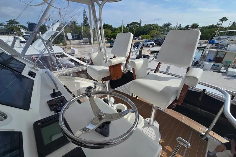 Slide: The Image of Helm of 2006 Jersey Cape 44 Convertible yacht with white captain chairs and steering wheel. - 29