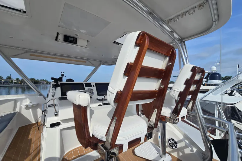 Slide: The Image of Luxurious helm of 2006 Jersey Cape 44 Convertible yacht with wooden chairs and navigation equipment. - 30