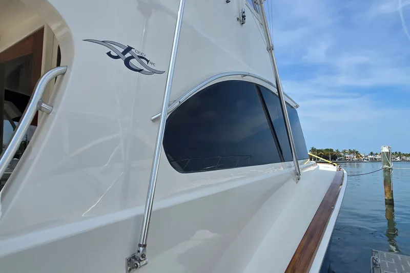Slide: The Image of 2006 Jersey Cape 44 Convertible yacht docked by the water on a sunny day. - 33