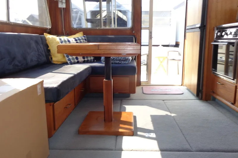 Slide: The Image of 1987 Tollycraft 34 Convertible Sedan interior with cozy seating and wooden table. - 25
