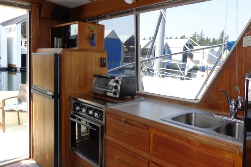 Slide: The Image of Interior of 1987 Tollycraft 34 Convertible Sedan with kitchen appliances and marina view. - 26