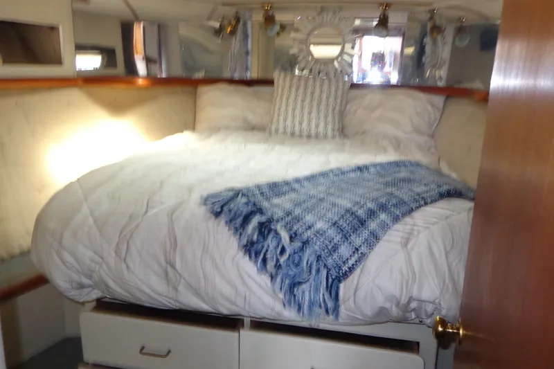 Slide: The Image of Cozy bedroom interior of 1987 Tollycraft 34 Convertible Sedan with plush bedding and nautical decor. - 18