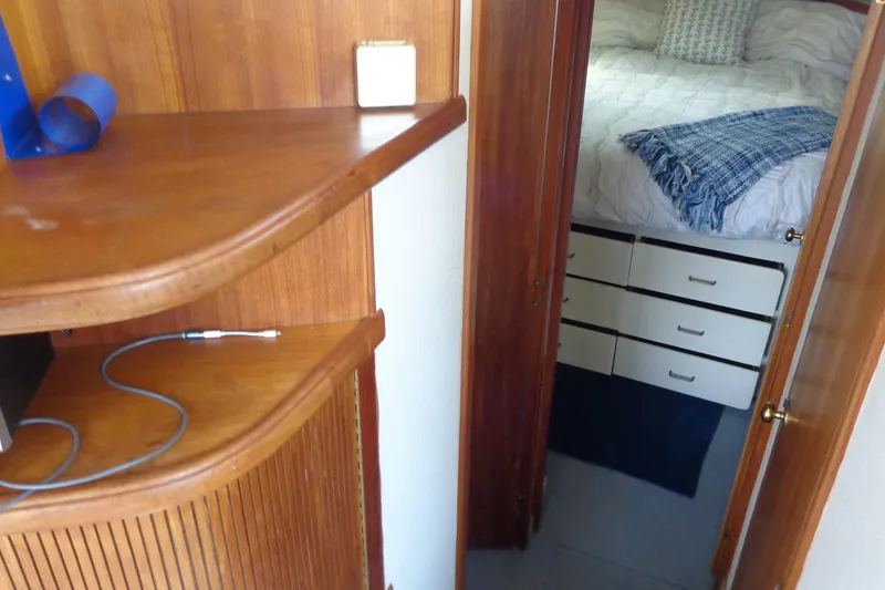 Slide: The Image of 1987 Tollycraft 34 Convertible Sedan interior with wooden cabinetry and cozy bedroom view. - 17