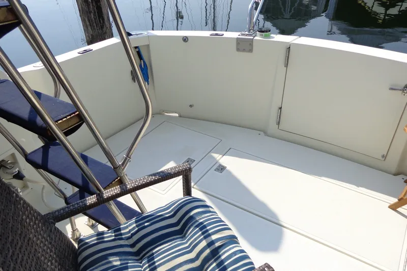 Slide: The Image of 1987 Tollycraft 34 Convertible Sedan boat deck with striped cushion and ladder. - 27