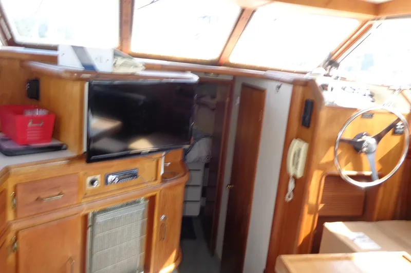 Slide: The Image of 1987 Tollycraft 34 Convertible Sedan interior with wooden cabinetry and steering wheel. - 14