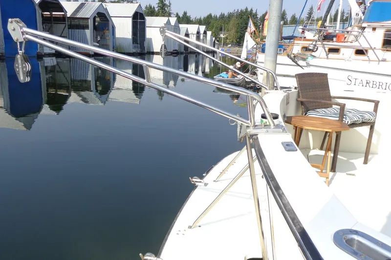 Slide: The Image of 1987 Tollycraft 34 Convertible Sedan docked, featuring deck seating and marina view. - 7
