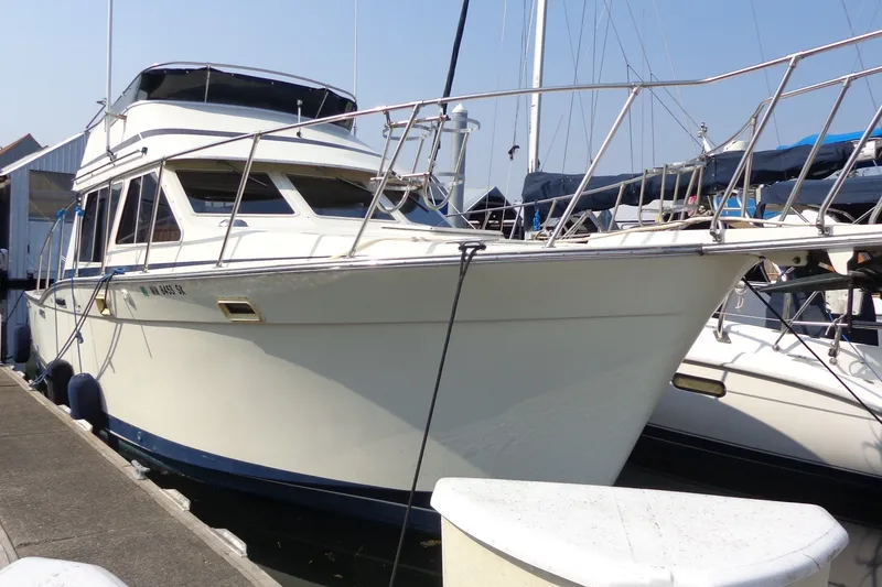 Slide: The Image of 1987 Tollycraft 34 Convertible Sedan docked at marina, showcasing classic design and structure. - 2