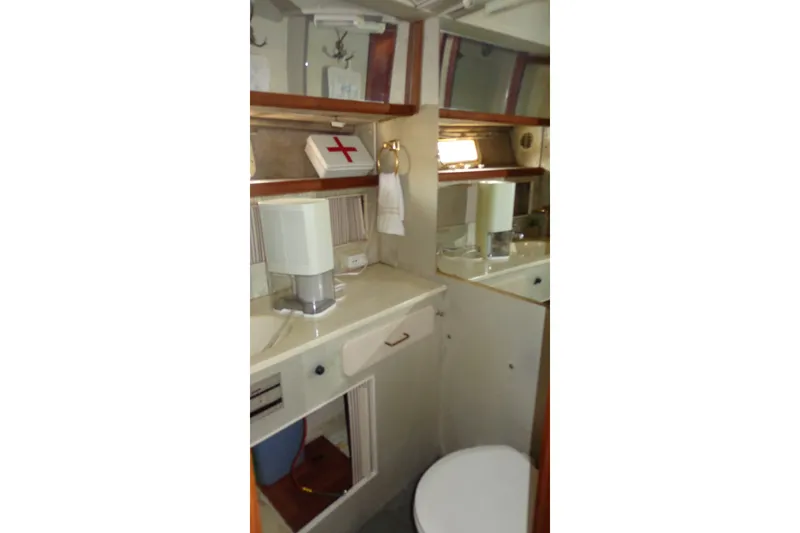 Slide: The Image of 1987 Tollycraft 34 Convertible Sedan bathroom with sink, mirror, and first aid kit. - 23