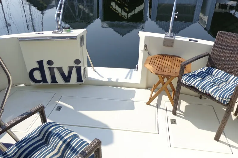 Slide: The Image of 1987 Tollycraft 34 Convertible Sedan deck with chairs and table by the water. - 8
