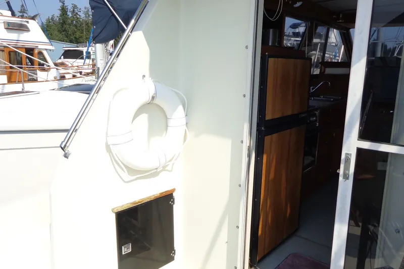 Slide: The Image of 1987 Tollycraft 34 Convertible Sedan boat interior with life preserver and wooden cabinetry. - 10
