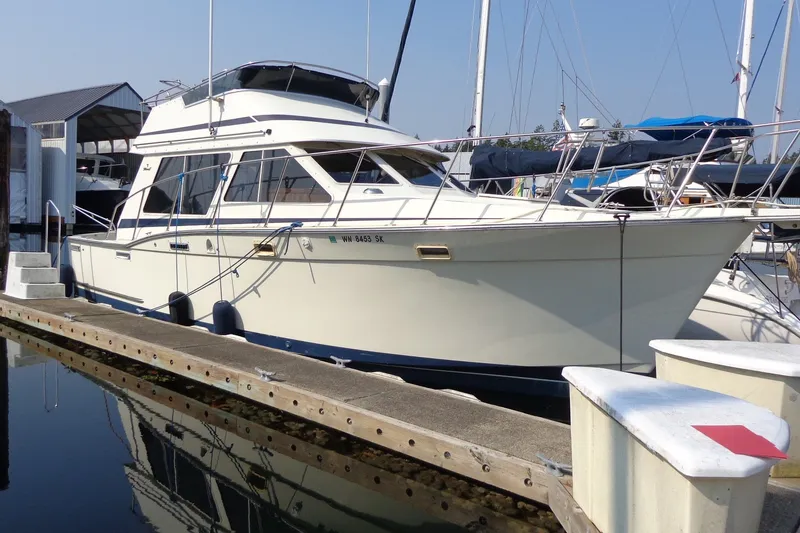 The Image of 1987 Tollycraft 34 Convertible Sedan docked at marina, side view. - 1