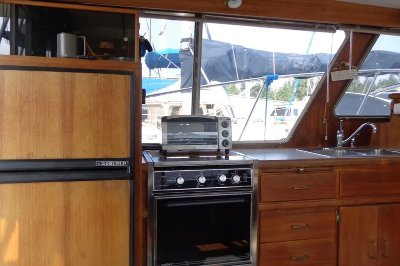 Slide: The Image of Interior of 1987 Tollycraft 34 Convertible Sedan with kitchen appliances and wooden cabinetry. - 13