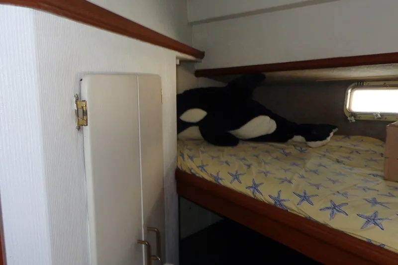 Slide: The Image of 1987 Tollycraft 34 Convertible Sedan cabin with starfish bedding and plush orca toy. - 22