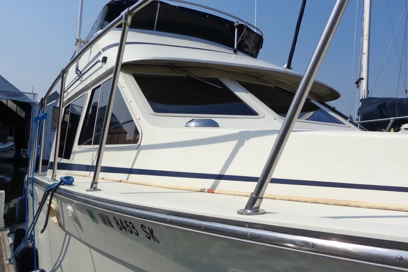 Slide: The Image of 1987 Tollycraft 34 Convertible Sedan boat docked, showcasing sleek design and windows. - 4