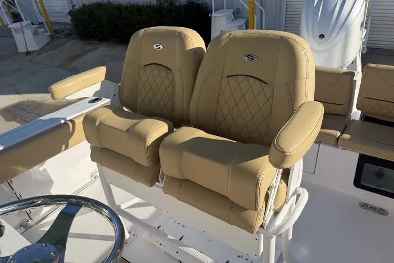 Slide: The Image of 2025 Sportsman Heritage 231 Center Console boat with tan cushioned seats and steering wheel. - 44